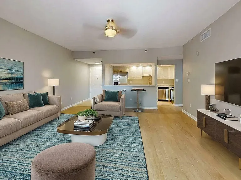 Inviting living area with elegant furniture, modern decor, and an open layout connecting to a sleek kitchen.