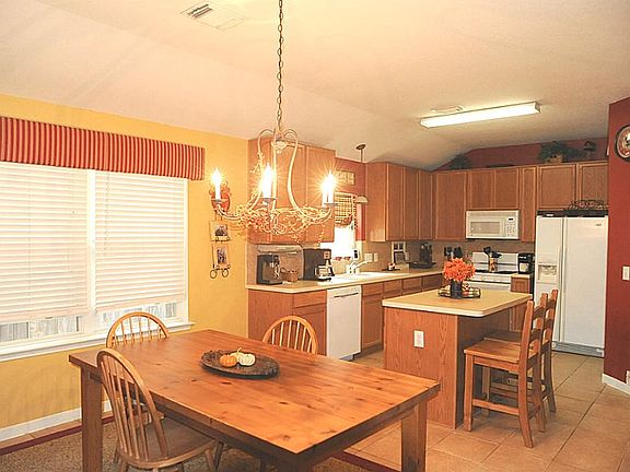 Kitchen and dining area with tile floors, 2" blinds, and new light fixtures.