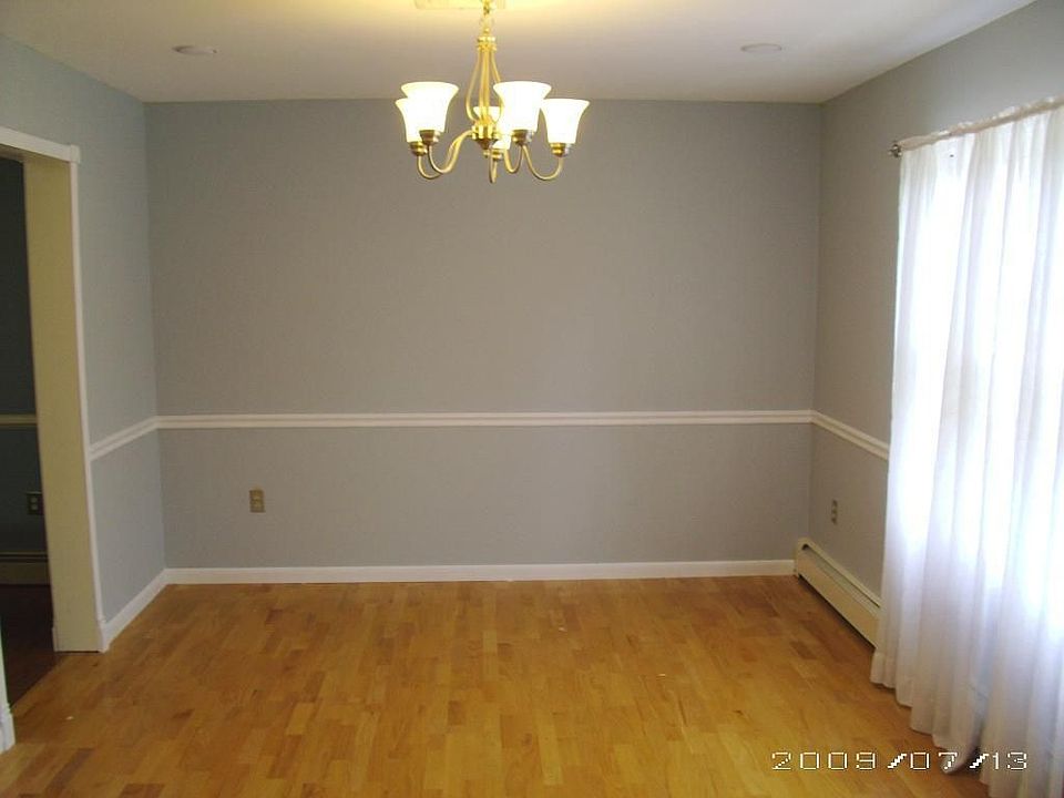 Formal dining room with chair-rail and brushed nickel chandelier.