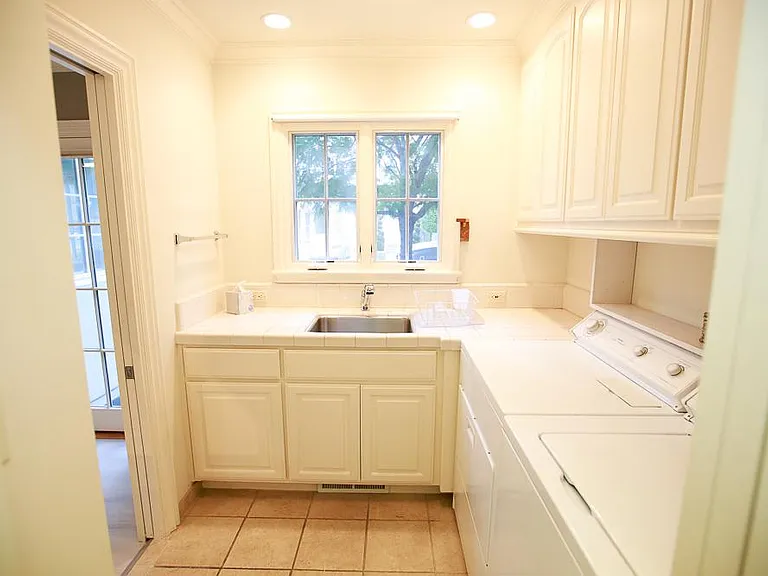 Standalone laundry area with pocket door, large utility sink with a nice view, full-size washer and dryer, and more built-in storage than any family could possibly need.
