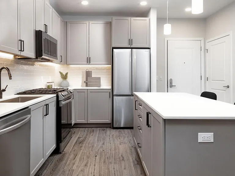 Upgrade Scheme kitchen with stainless steel appliances, white quartz countertops, grey cabinetry, and hard surface flooring