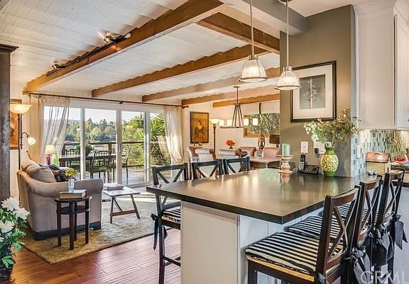 Living room as seen from the entry way. Nice open kitchen with built-in eating area. Sliders open to
