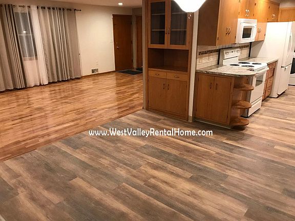 New flooring in kitchen and kitchenette area, leading into newly finished hardwood living room