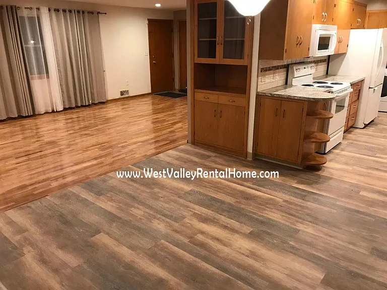 New flooring in kitchen and kitchenette area, leading into newly finished hardwood living room