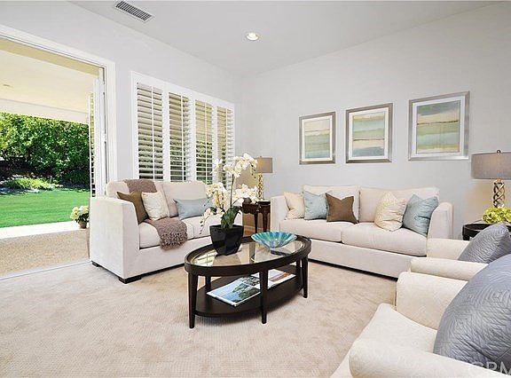 A Lovely Living Room with new neutral designer paint and carpet with French Doors that open to the e