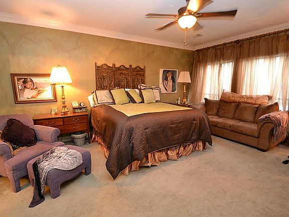 Master bedroom complimented by double crown molding and a ceiling fan with light fixture.