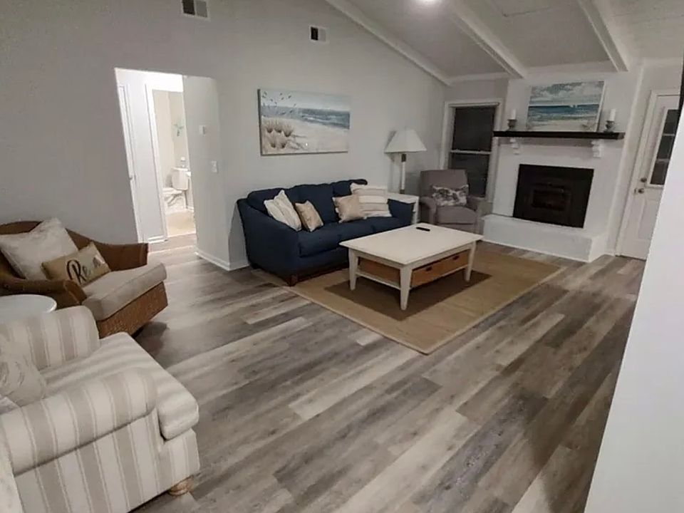 Large Living Room looking out to fenced in back yard and Open concept Kitchen