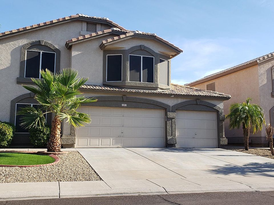 Front yard with artificial grass. 3 car garage
