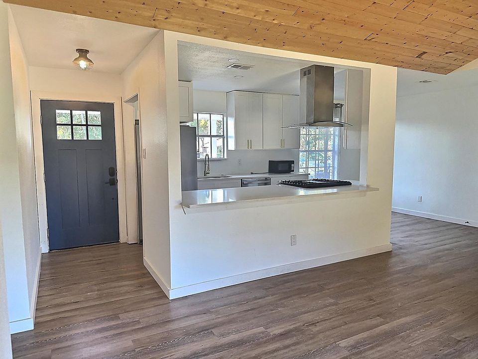 open concept kitchen/dining/living space with vaulted ceilings