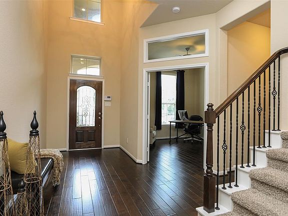 Spacious study with solid doors and transom window. Powder bath is located down the hall to the right. Iron ballusters enhance the stairway to game, media and bedrooms.