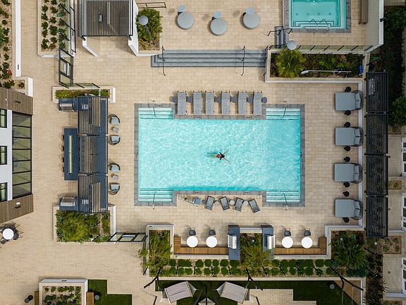 Pool deck with plenty of seating next to hammock garden