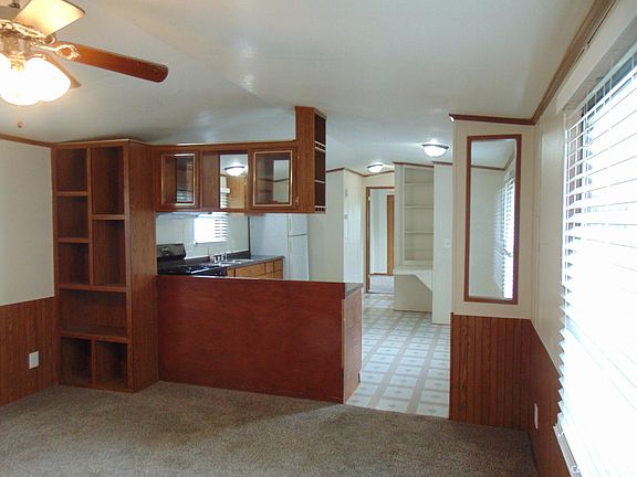 Front room has plenty of shelving and new decorative blinds on the windows