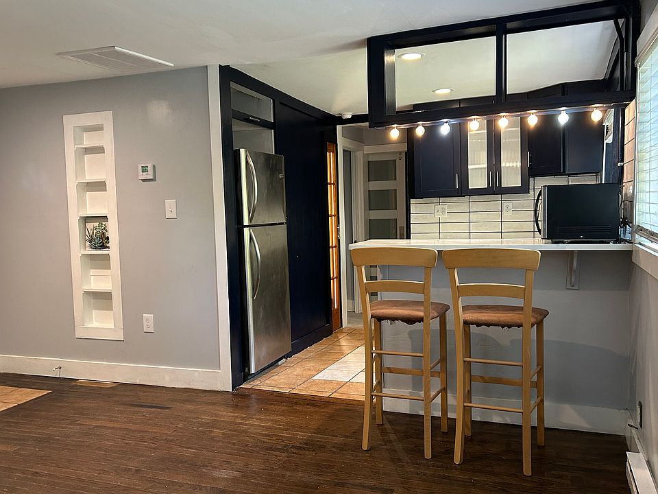 Living Room view to Kitchen ,Breakfast Bar, and Hallway with Contemporary Door