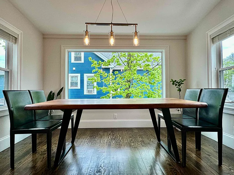 Bright sunroom-style dining area with a large picture window and beautiful four-season Melrose views.