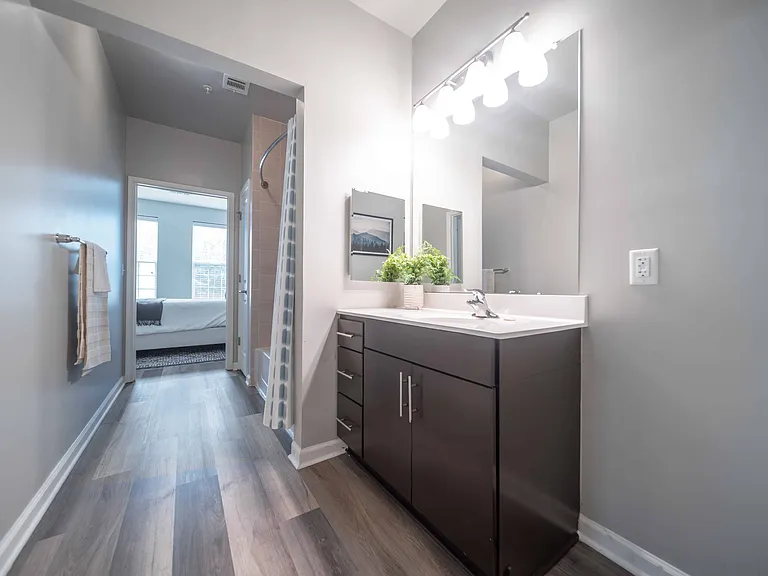 A bathroom with a vanity, mirror, and lights at Harbor Pointe, Bayonne