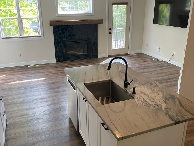 Kitchen open open to large family room with fireplace and balcony