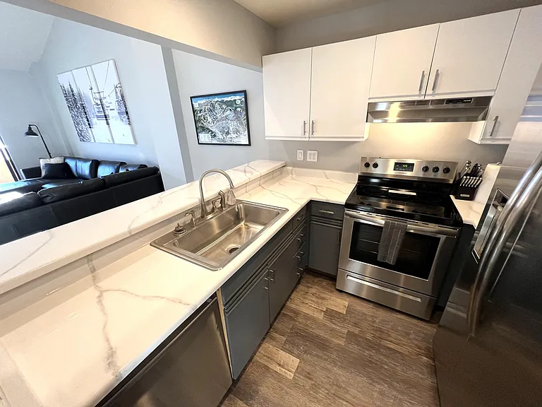 Kitchen with bar with seating for four, stainless appliances, refrigerator with filtered water and ice maker in door, Bosch quiet dishwasher