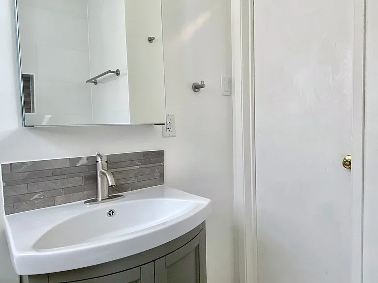Mirrored vanity and cabinet with ample storage.