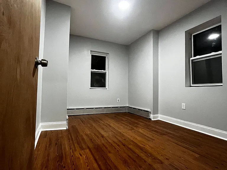 Primary bedroom featuring new laminate flooring, fresh paint, and dual windows for great natural light