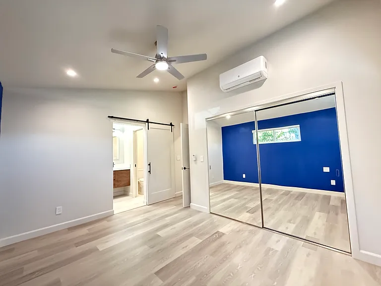 Main bedroom suite with vaulted ceilings, recessed lighting, overhead fan, blackout shades and large closet with built in cabinet organizer.