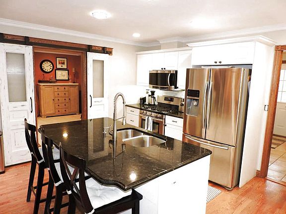 Captivating kitchen with black granite and white cabinets.  