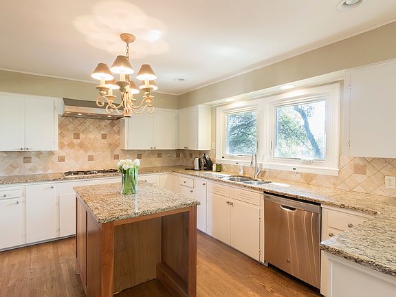 Spacious, bright kitchen. Island now has wine fridge. Gas stovetop cooktop with 5 burners.