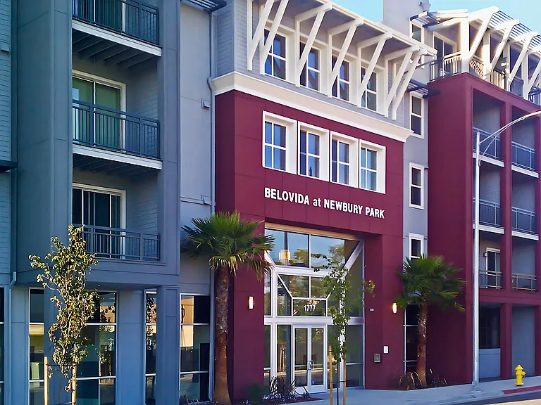 Modern exterior at Belovida at Newbury Park, featuring bold architecture, palm-lined entry, and a welcoming feeling.