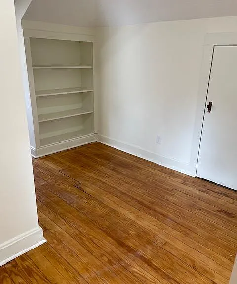 Landing area with built in bookcases and door to additional storage.