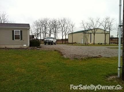house and pole barn with gravel driveway