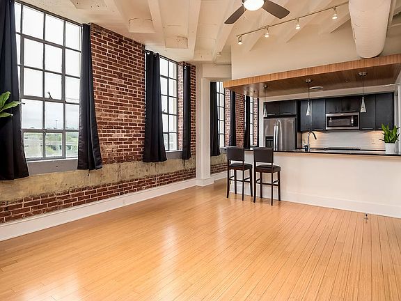 Large windows, open floor plan with kitchen and bar