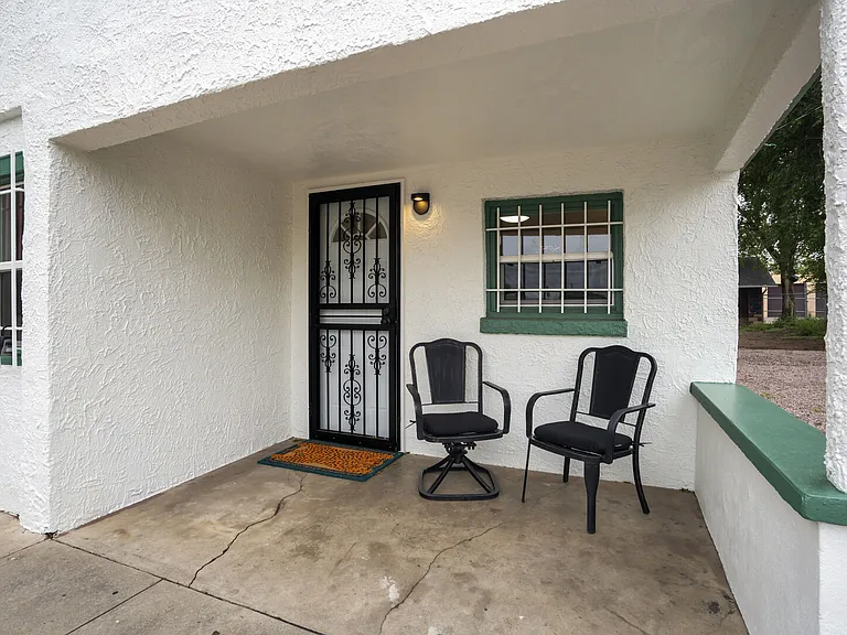Step up to the cozy front porch with a place to sit and enjoy the neighborhood vibe.