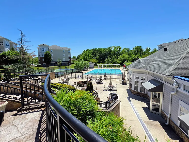 Elevated view overlooking the pristine community pool deck, surrounding green spaces, and neighborhood recreation options.