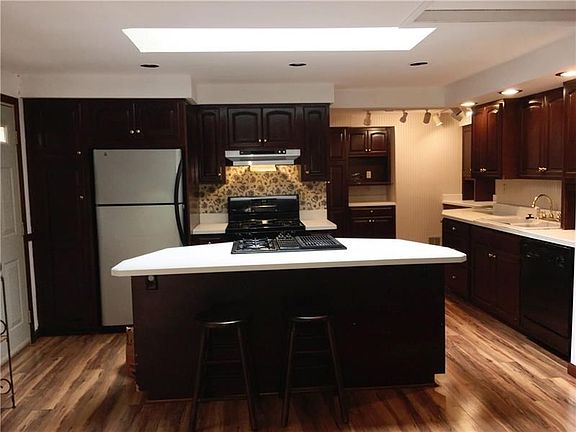 This large chef's kitchen has new flooring and loads of counter space as well and a gas stove and gas cooktop with skylight for 