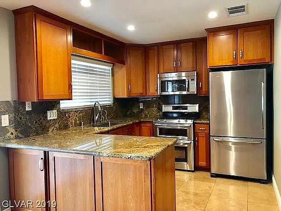 Kitchen with cherry wood cabinets, stainless steel appliances and granite countertops