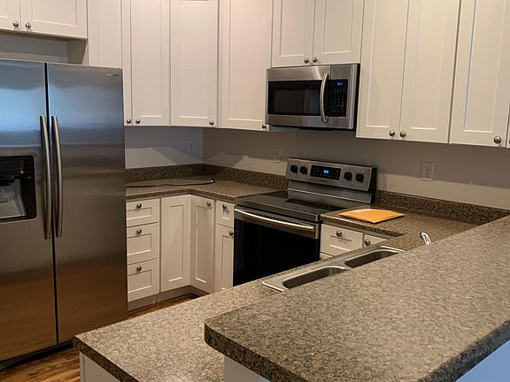 Kitchen with stainless steel appliances: microwave, frig and stove. Stove had ceramic cook top. Sink has garbage disposal.