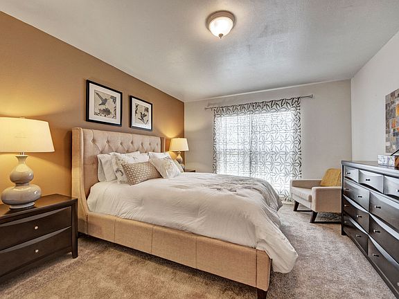 A bedroom with overhead lighting and a sliding glass door out to the patio