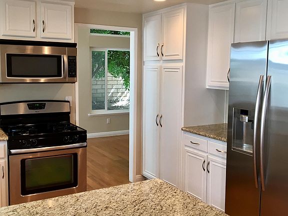 Bright kitchen with granite counter tops and stainless steel appliances. Six overhead recessed lights on dimmer switch -- allows you to adjust light.