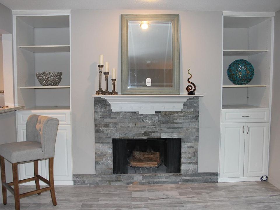 living room stone fire place with bookshelves on the sides w