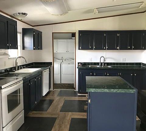 The Kitchen has more than ample cabinet space. The full size, over and under refrigerator is also located in the rear entry area. Three overhead light fixtures provide ample light for preparing meals.
