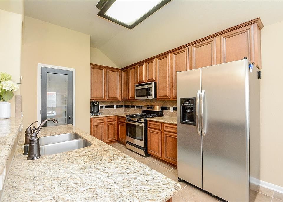 42" Camden maple kitchen cabinets with stainless steel appliances and beautiful glass pantry door.