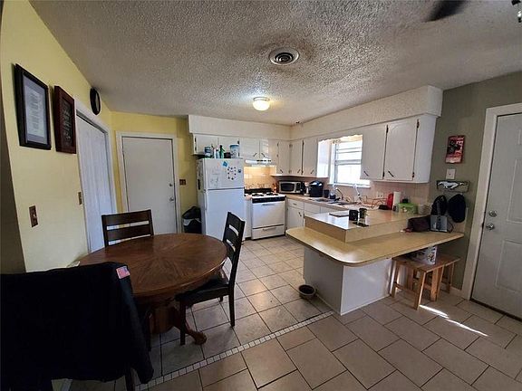 Kitchen and dining area with front door to far right.