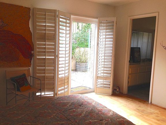 Sliding Glass doors with White Wood Shudders to back yard