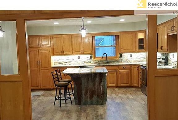 Incredibly large kitchen with slate backsplash, granite countertops, recessed lighting, under counter lighting, new hardware, sink and faucet.  New flooring.  Restoration look with corrugated steel island with granite top.