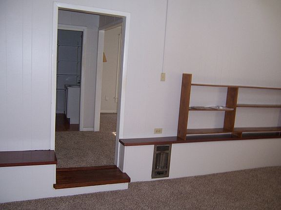 living room step up through door to bedroom and bath