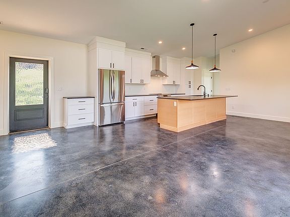 Entry into kitchen and light filled spacious living and dining area.