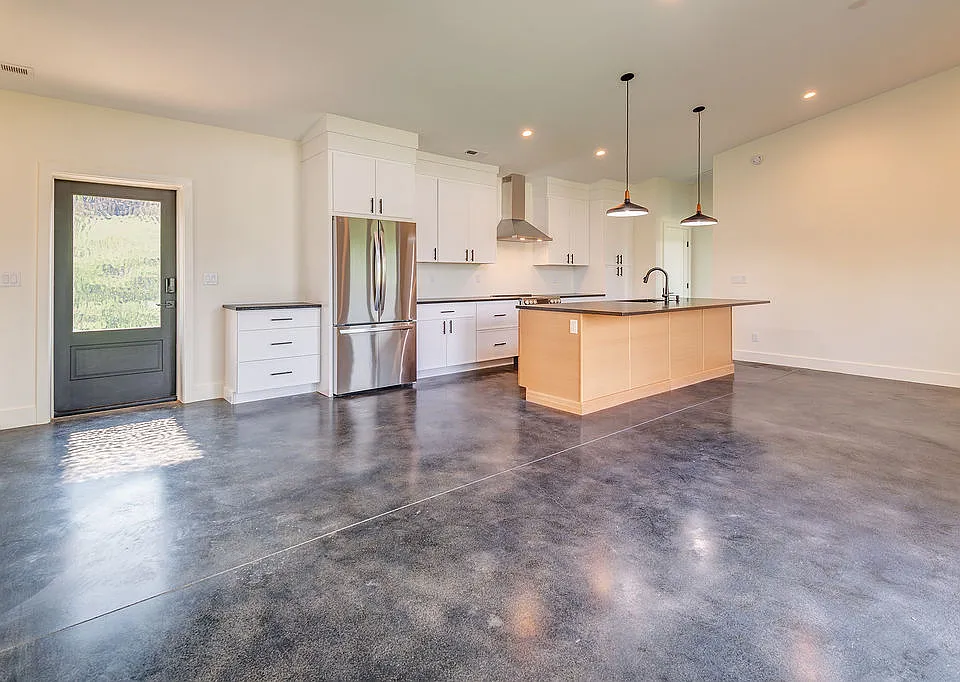 Entry into kitchen and light filled spacious living and dining area.