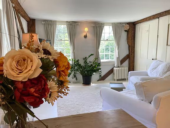 A view from your dining table in the Salon looking out over sunny the room & your front yard. Behind the flowers, is a 55" inch TV that swivels so it can be enjoyed from your dining table.