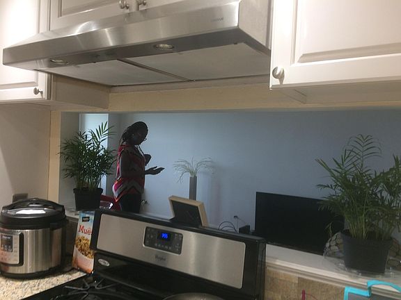 Another view of the renovated kitchen with white cabinets, stainless appliances and granite countertops