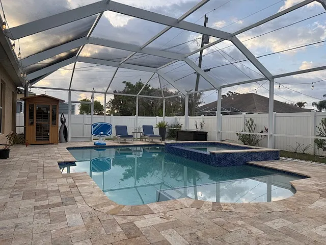 Beautiful screened pool area with spa and large patio, ideal for outdoor living.