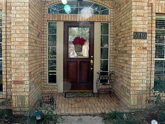 Inviting entry with brick surround and gorgeous lead glass  wood front door.